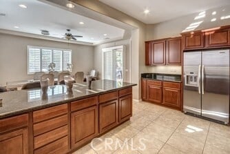 kitchen with ceiling fan, stainless steel fridge, and light tile patterned floors