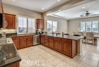 kitchen with kitchen peninsula, dishwasher, ceiling fan, and plenty of natural light