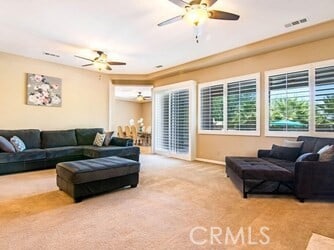 living room featuring ceiling fan and light carpet