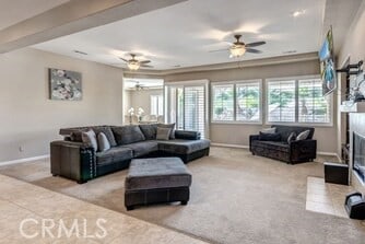 carpeted living room with ceiling fan