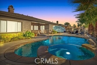 pool at dusk with a patio