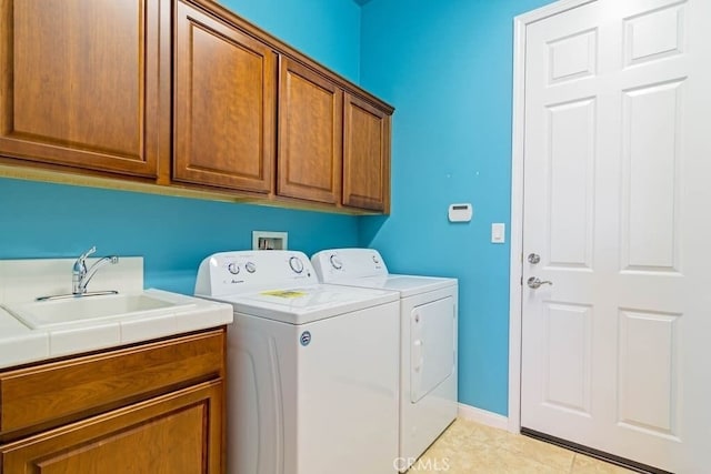 laundry room with cabinets, independent washer and dryer, light tile patterned flooring, and sink