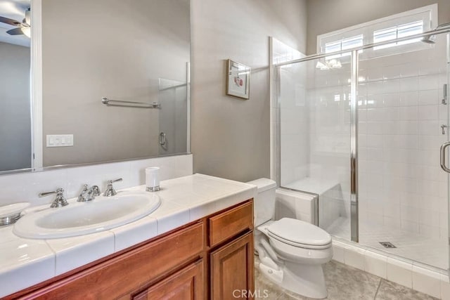 bathroom featuring walk in shower, vanity, toilet, and ceiling fan