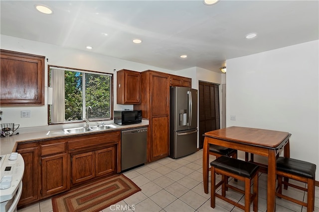 kitchen with light tile patterned flooring, sink, and stainless steel appliances