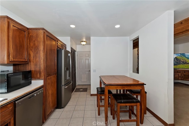 kitchen with light tile patterned floors and stainless steel appliances