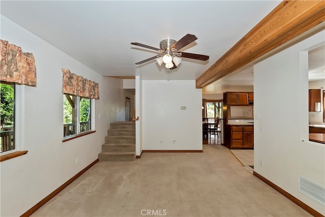 unfurnished living room with a healthy amount of sunlight, light carpet, and ceiling fan