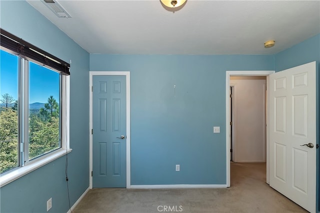 unfurnished bedroom featuring light carpet