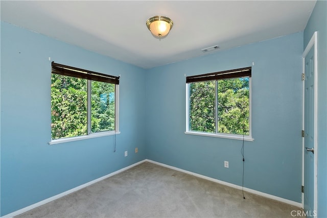 spare room with light colored carpet and plenty of natural light