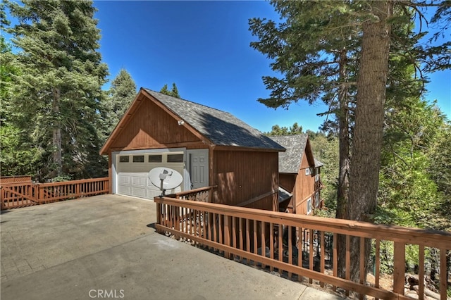 view of side of home with a garage, an outdoor structure, and a deck