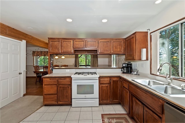 kitchen featuring light tile patterned flooring, sink, kitchen peninsula, stainless steel dishwasher, and white range