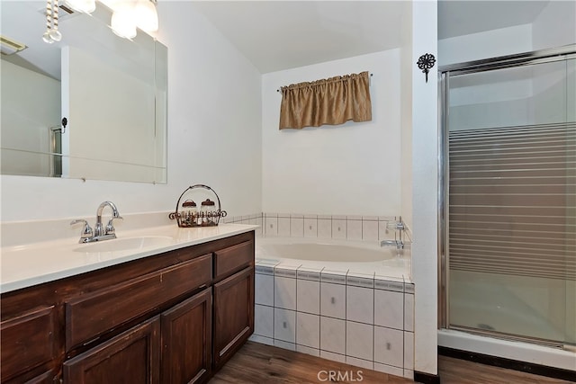 bathroom featuring vanity, hardwood / wood-style flooring, and plus walk in shower