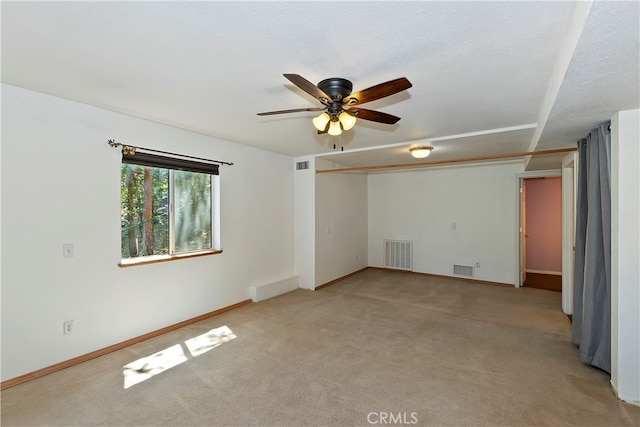 carpeted spare room featuring ceiling fan and a textured ceiling