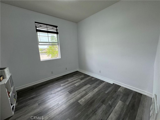 empty room with dark hardwood / wood-style flooring