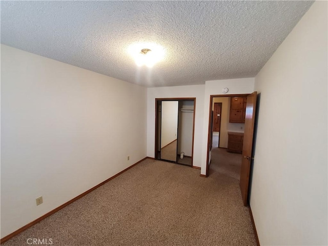 unfurnished bedroom with a textured ceiling, light colored carpet, and a closet