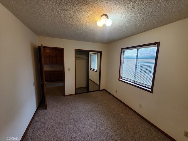 unfurnished bedroom with carpet flooring and a textured ceiling