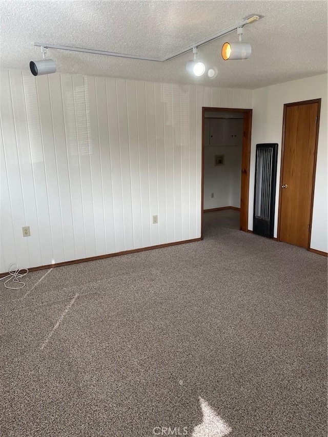 carpeted empty room featuring a textured ceiling