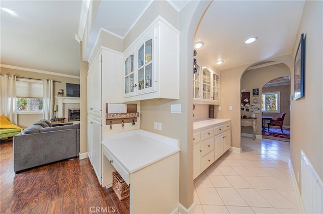46469 Wallu Ln, Ahwahnee, CA 93601 - kitchen featuring arched walkways, glass insert cabinets, white cabinetry, and a wealth of natural light