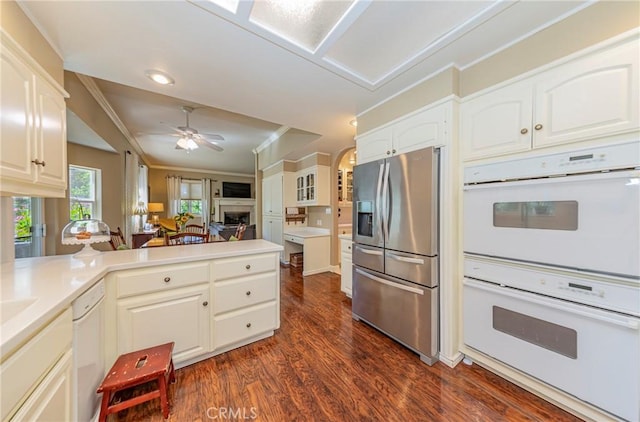 46469 Wallu Ln, Ahwahnee, CA 93601 - kitchen featuring dark wood-style flooring, a peninsula, crown molding, white appliances, and white cabinetry