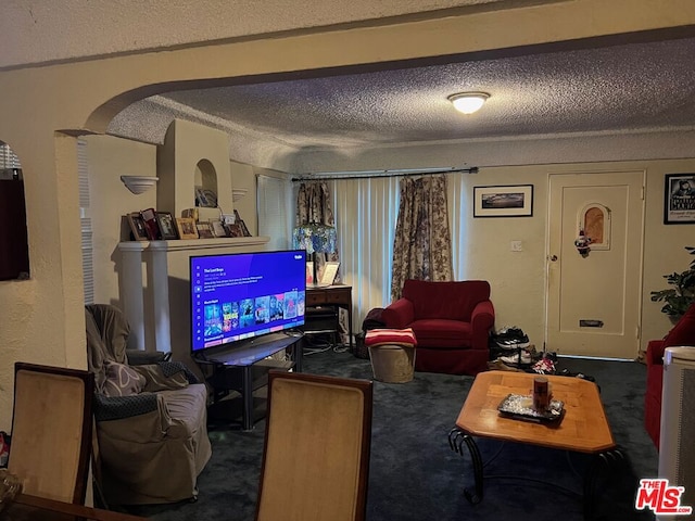 carpeted living room featuring a textured ceiling