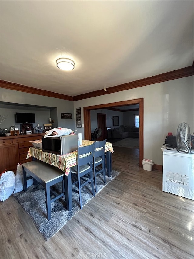 interior space with light wood-type flooring and crown molding