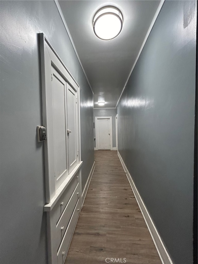 hall featuring ornamental molding and dark wood-type flooring