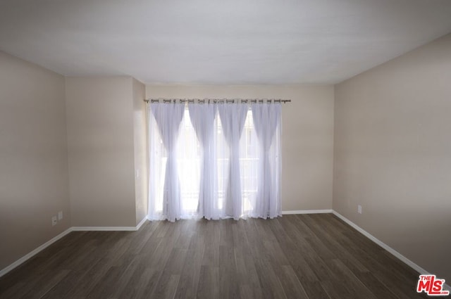 unfurnished room with dark hardwood / wood-style flooring