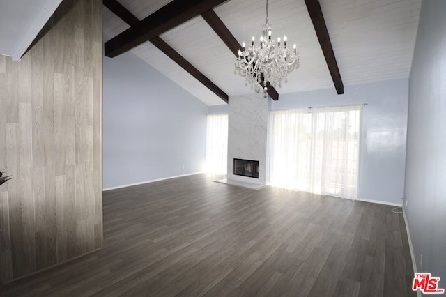 unfurnished living room featuring beam ceiling, a high end fireplace, wooden walls, dark wood-type flooring, and a chandelier