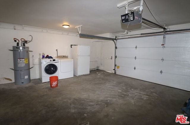 garage with washing machine and clothes dryer, a garage door opener, strapped water heater, and white fridge