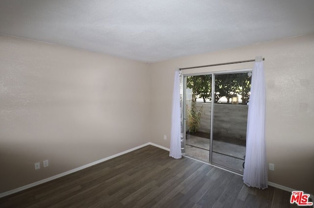 spare room with dark wood-type flooring