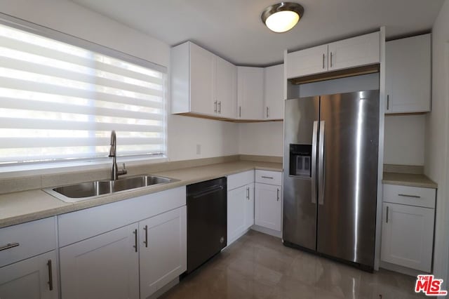 kitchen with stainless steel fridge, white cabinetry, dishwasher, and sink