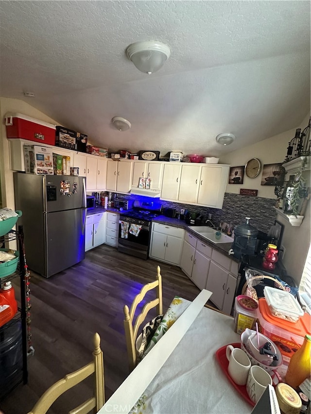 kitchen with dark wood-type flooring, sink, white cabinets, stainless steel refrigerator, and electric range oven