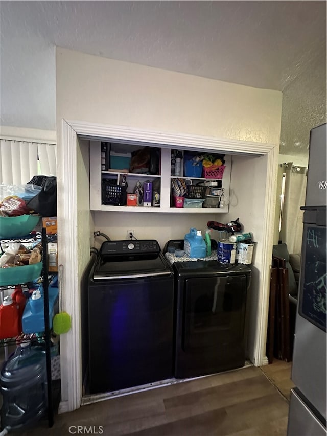 clothes washing area with washer and clothes dryer and hardwood / wood-style floors