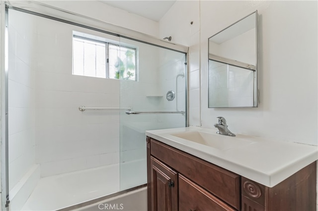 bathroom featuring enclosed tub / shower combo and vanity