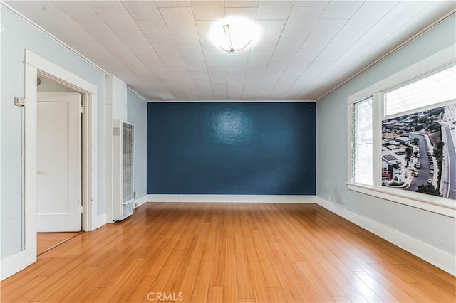 spare room with wood-type flooring and crown molding