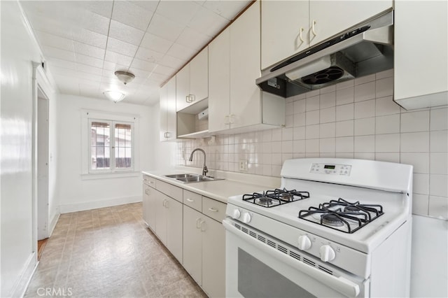 kitchen featuring white gas range, decorative backsplash, sink, and white cabinets