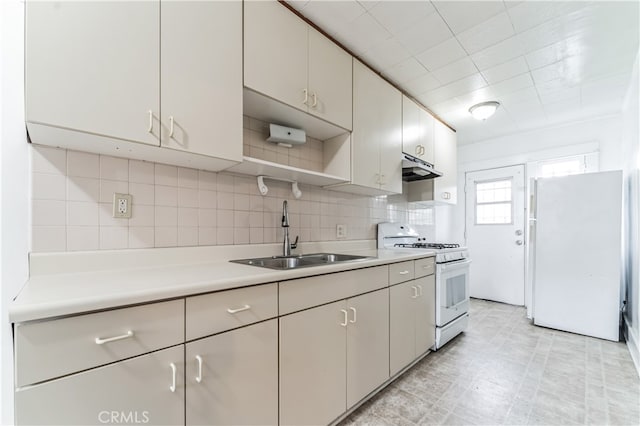 kitchen featuring white appliances, sink, and tasteful backsplash