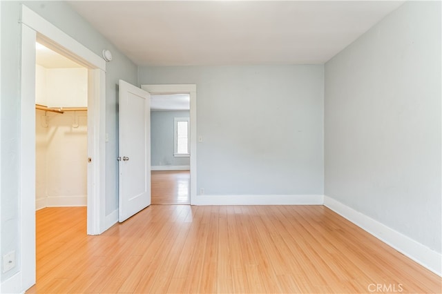 unfurnished bedroom with hardwood / wood-style flooring, a closet, and a spacious closet