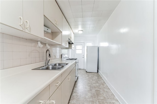 kitchen featuring sink, white appliances, and tasteful backsplash