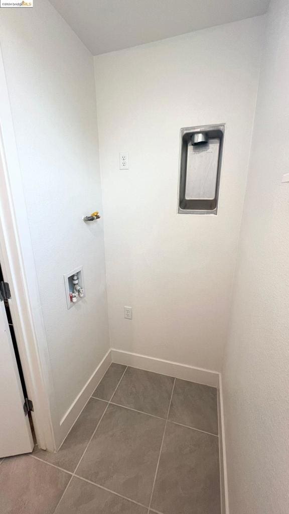 laundry room with washer hookup and dark tile patterned flooring