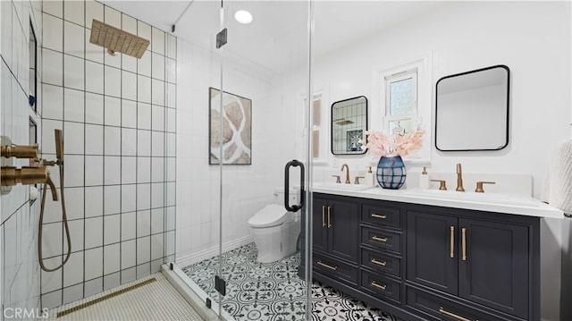 bathroom featuring tile walls, a shower with door, tile patterned floors, vanity, and toilet