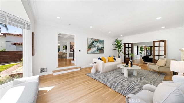 living room featuring light wood-type flooring, french doors, and plenty of natural light