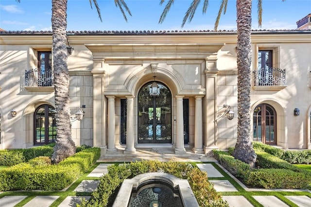 view of exterior entry with a balcony