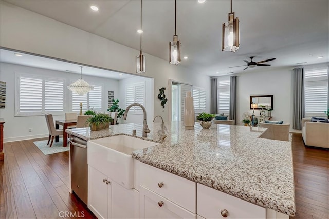 kitchen with a kitchen island with sink, dark wood-type flooring, decorative light fixtures, and stainless steel dishwasher