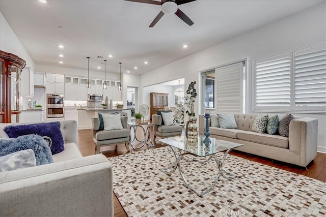 living room featuring ceiling fan and dark wood-type flooring