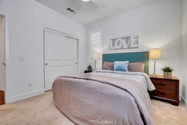 bedroom with light carpet, ceiling fan, and a closet