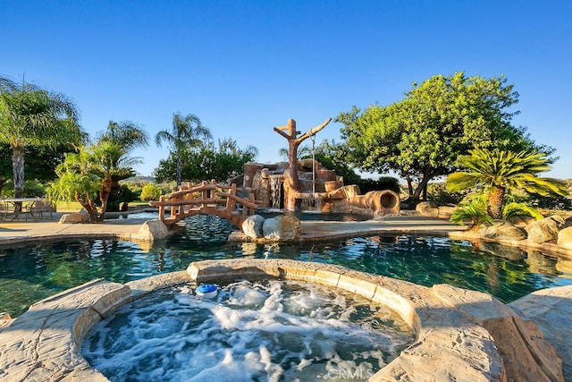 view of pool with an in ground hot tub