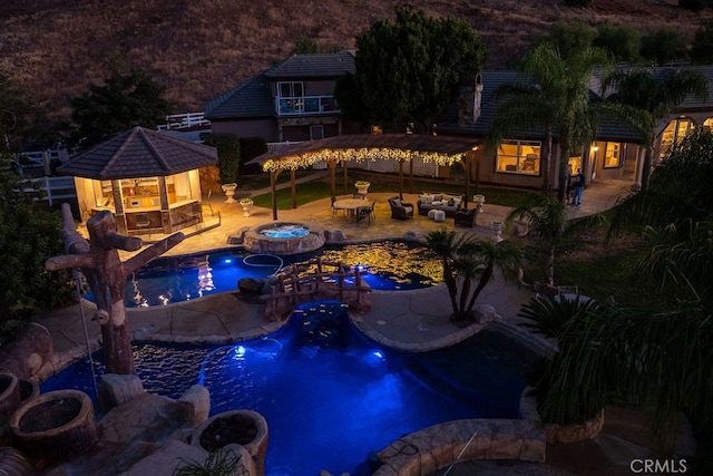 view of pool featuring an in ground hot tub, a patio area, and an outdoor living space with a fire pit