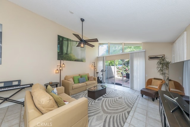 living room featuring lofted ceiling, ceiling fan, a textured ceiling, and light tile patterned floors