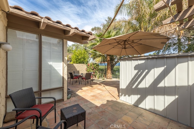 view of patio featuring a fenced backyard, a shed, and outdoor dining space