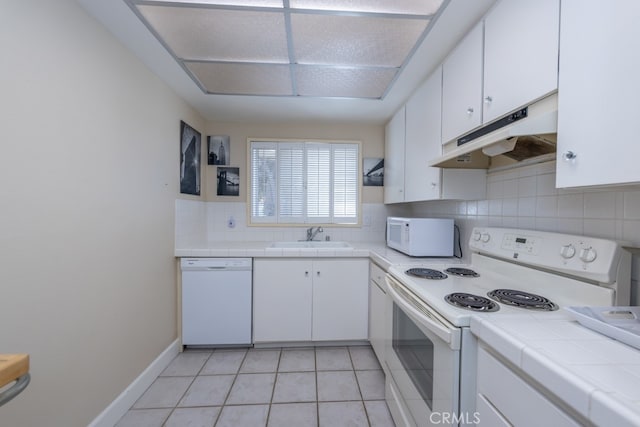 kitchen featuring white appliances, a sink, white cabinetry, and under cabinet range hood